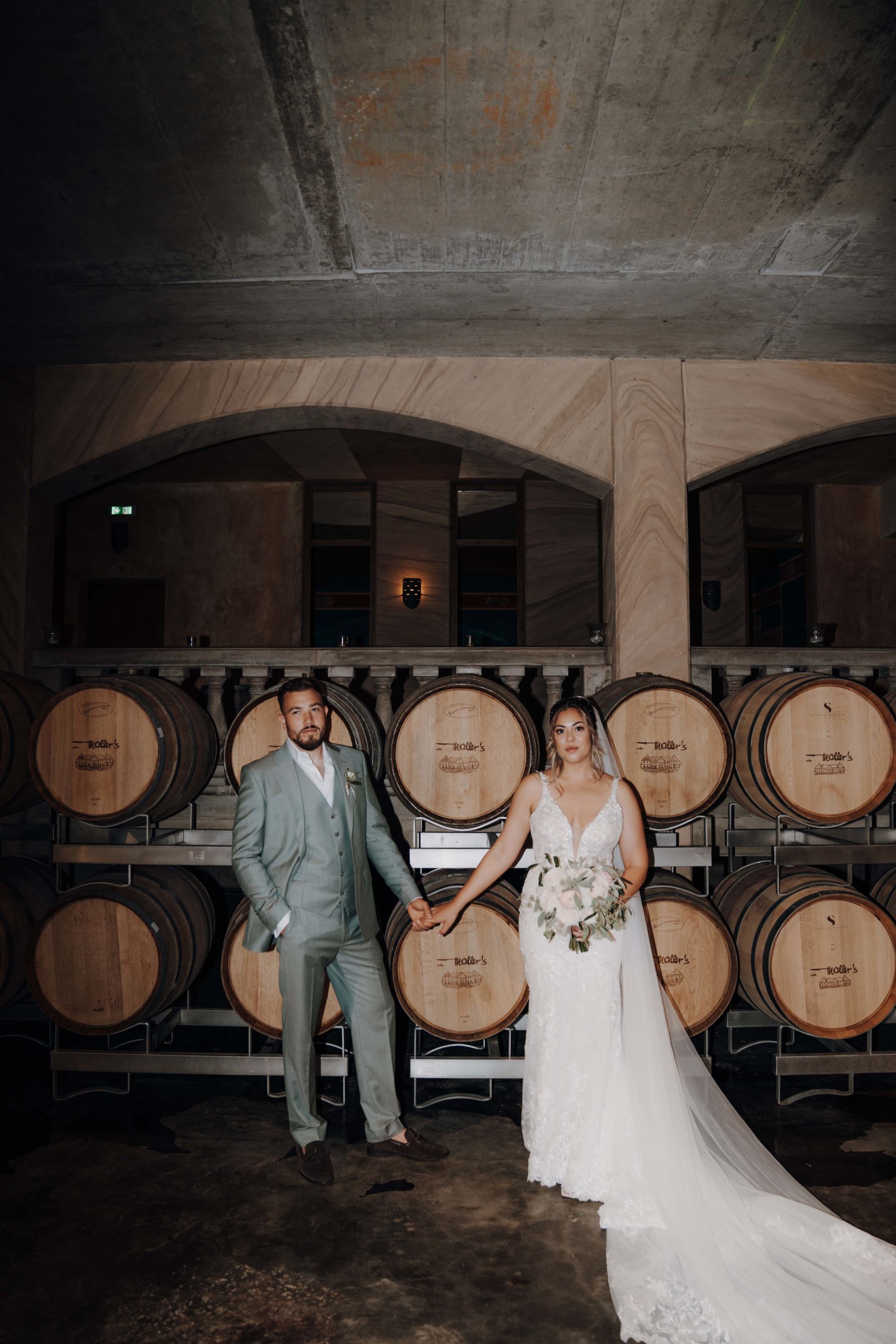 Brautpaar vor den Barriquefässern im Weinkeller vom Weingut
