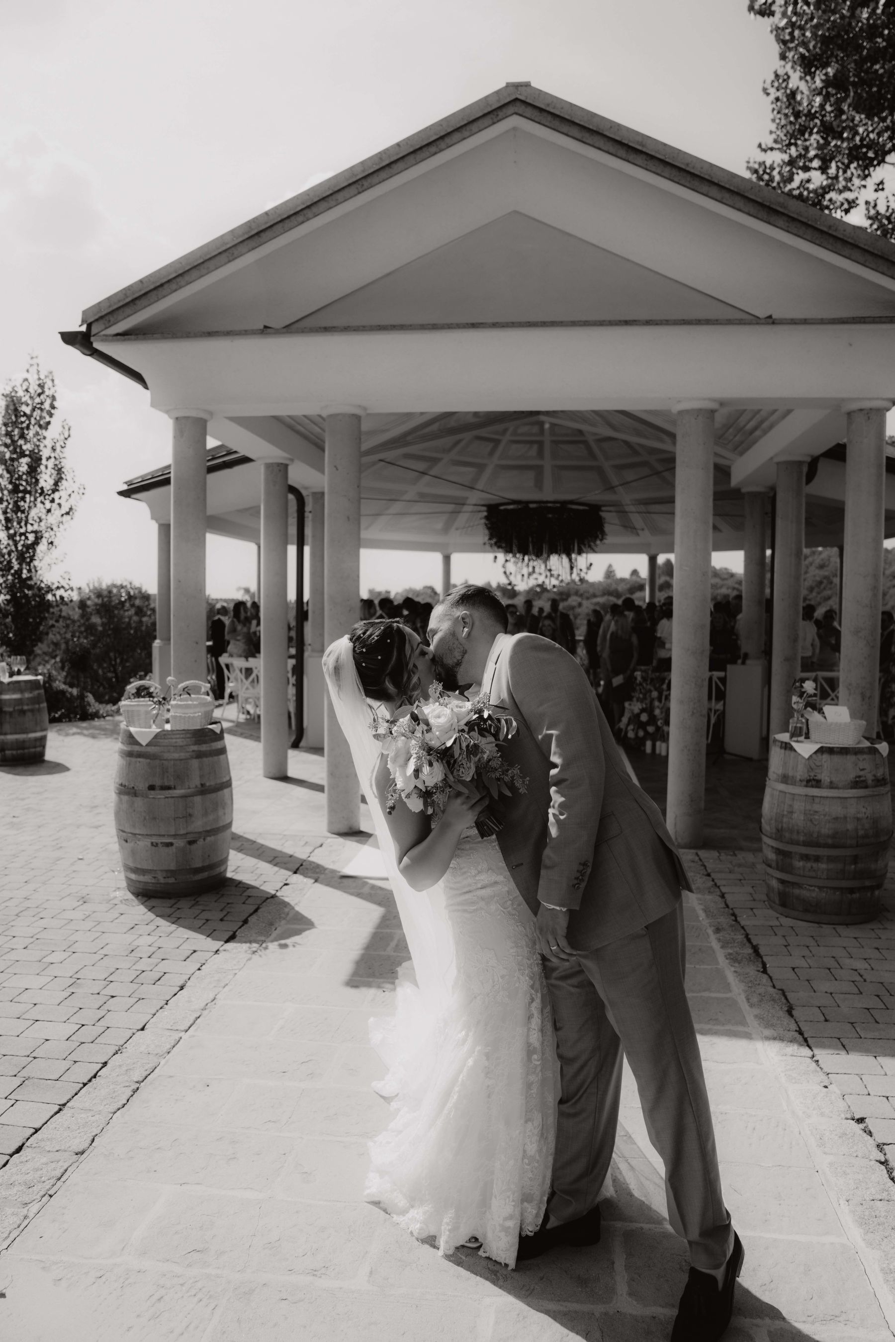 Brautpaar küsst sich vor dem Pavillon am Weinberg im Weinschloss Thaller