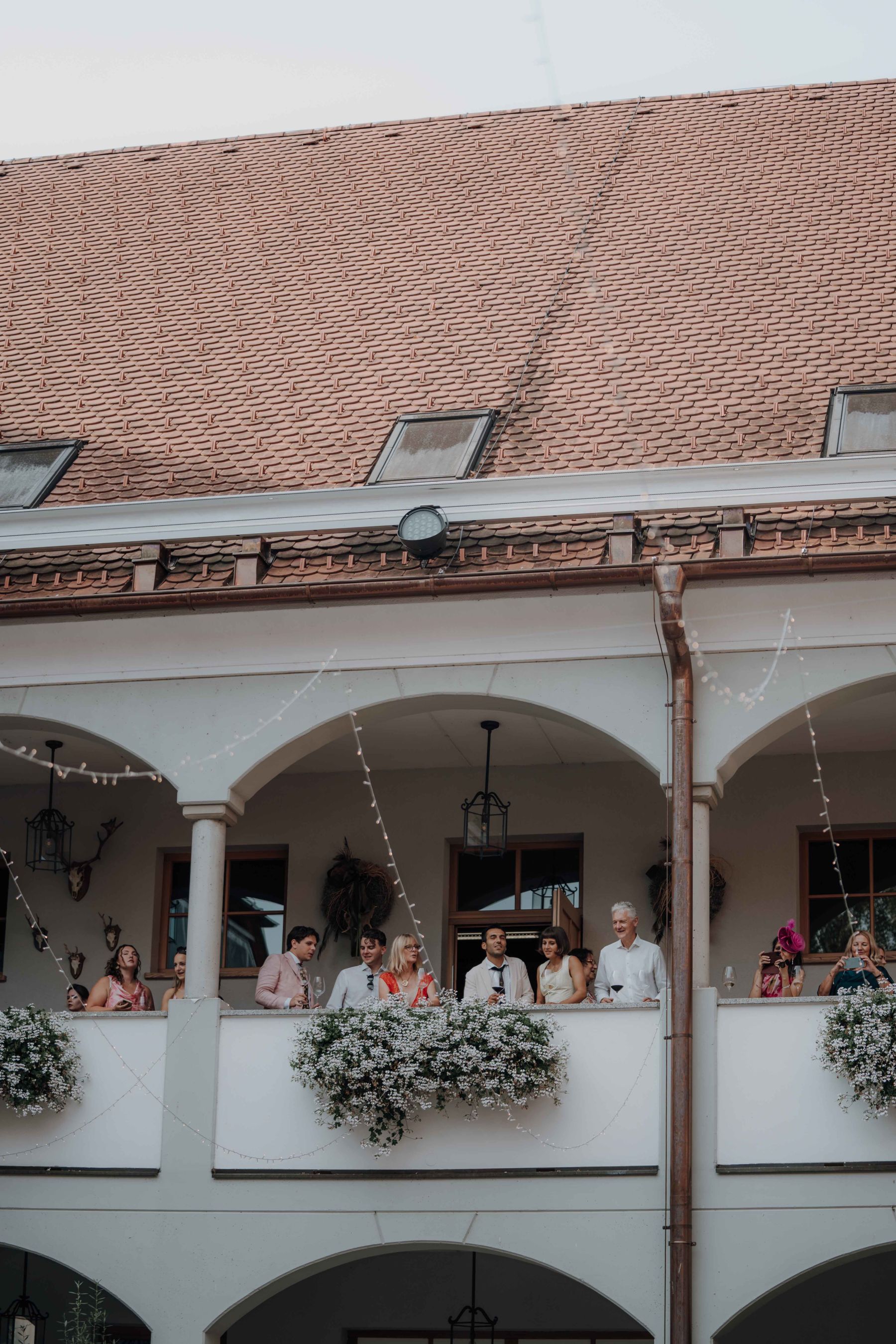 Gäste schauen von der Galerie im ersten Stock in den Innenhof
