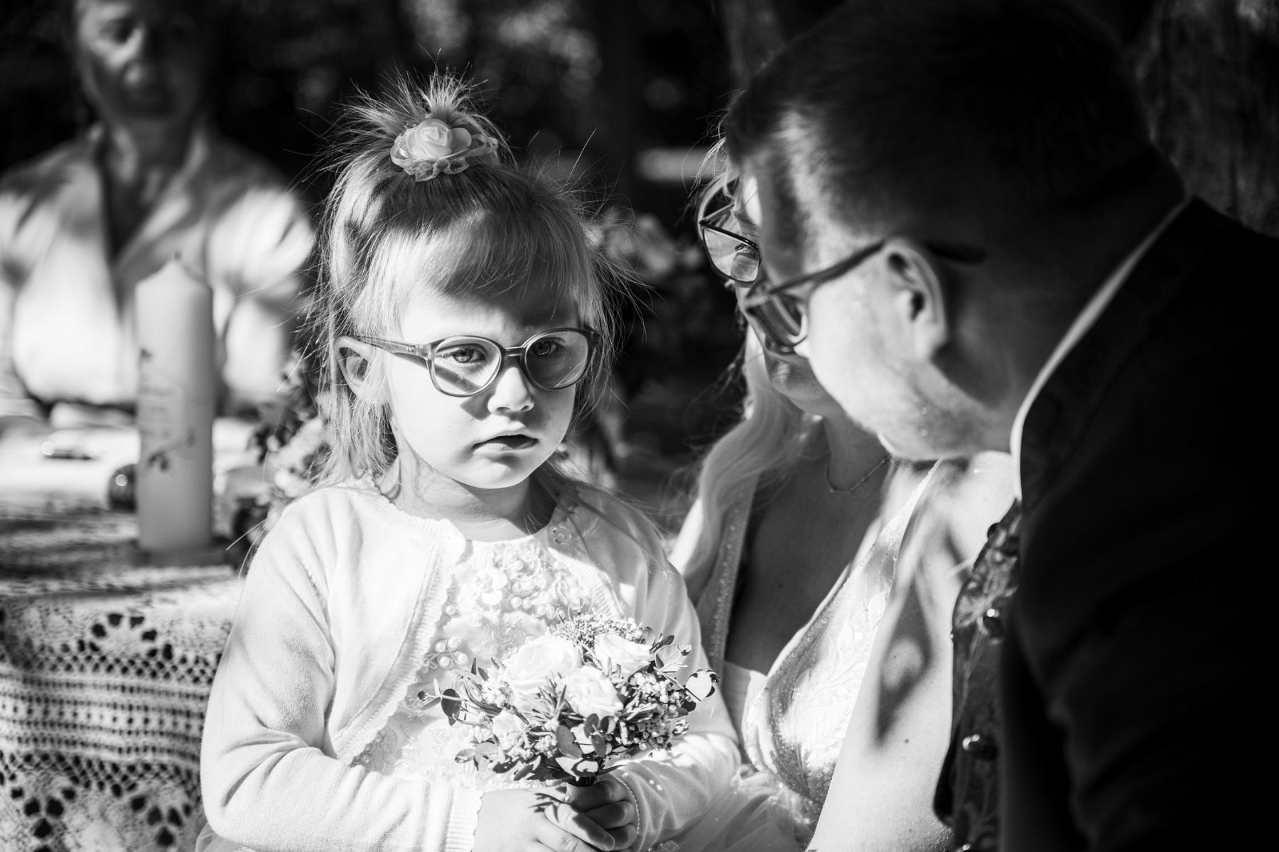 Brautpaar mit kleiner Tochter bei der Trauung auf der Liebesinsel am Vedahof – Mini-Brautstrauß (Schwarz-Weiß)