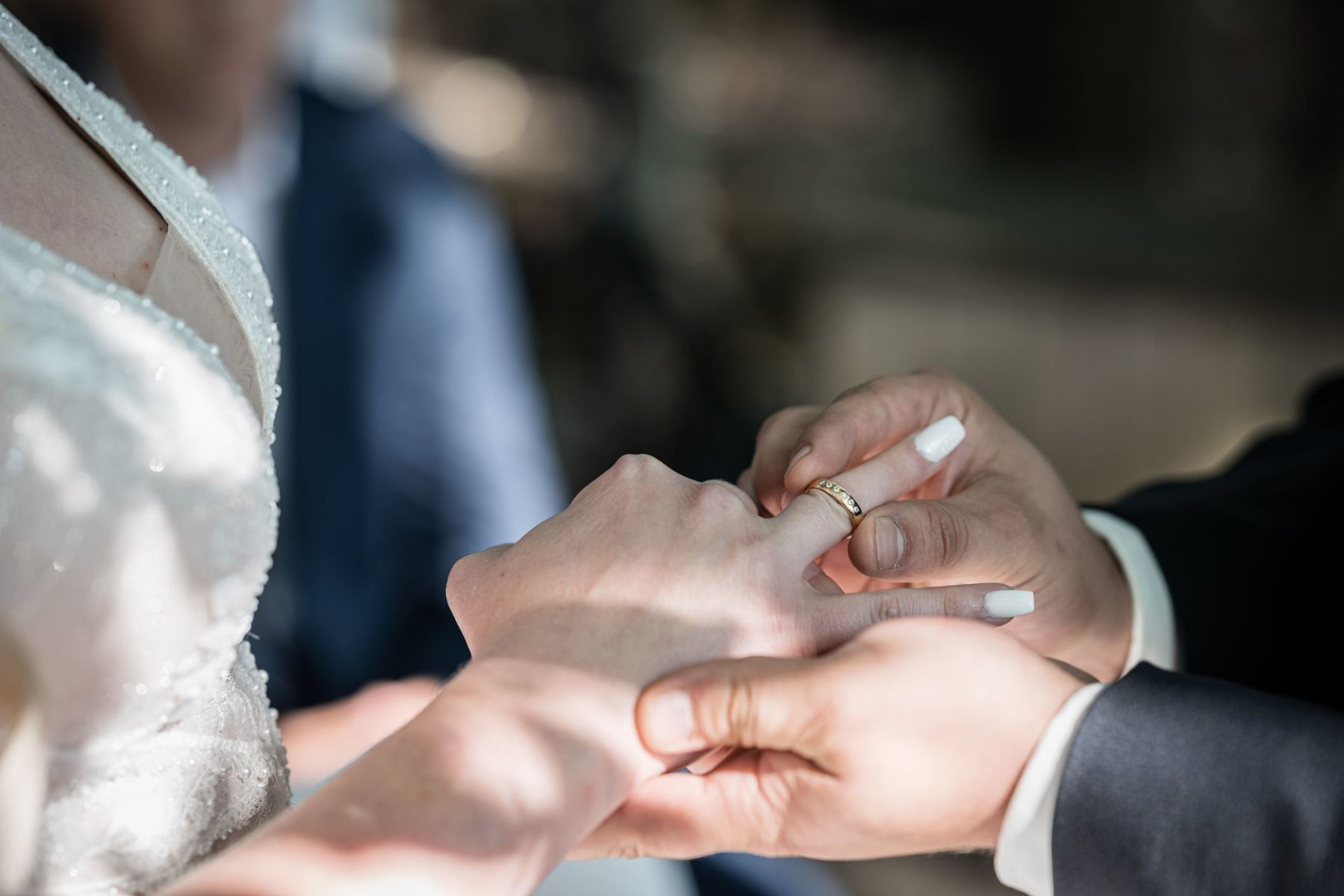 Detailaufnahme: Bräutigam steckt der Braut den Ehering auf der Liebesinsel am Vedahof an