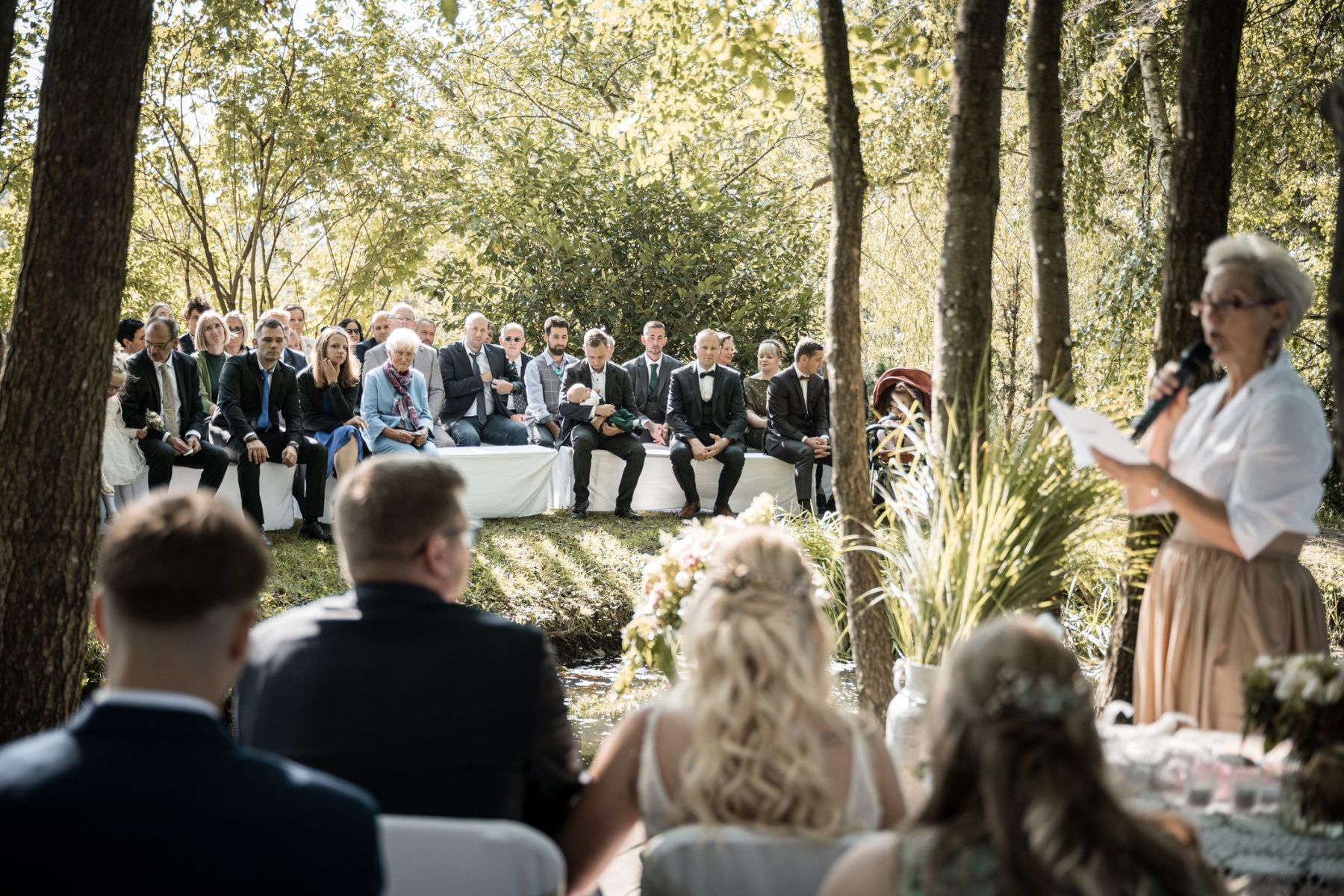 Blick der Brautleute von der Liebesinsel am Vedahof – Gäste an Land im Fokus