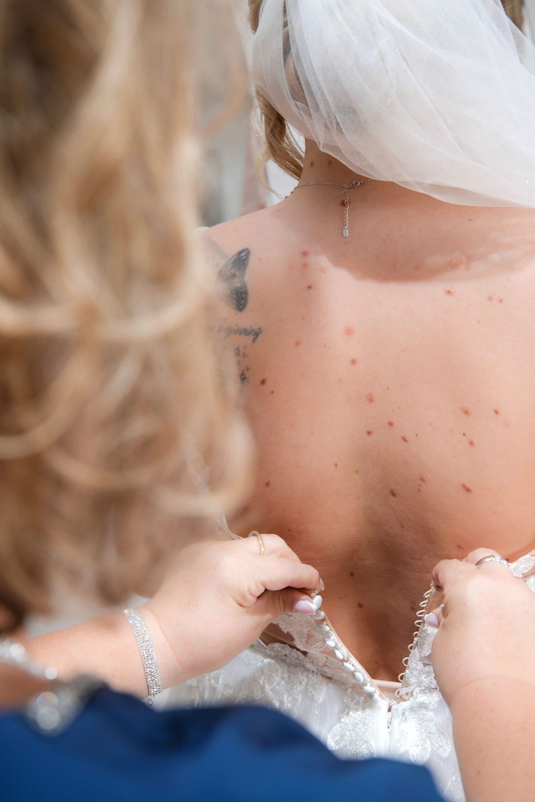 Braut schlüpft in ihr Brautkleid