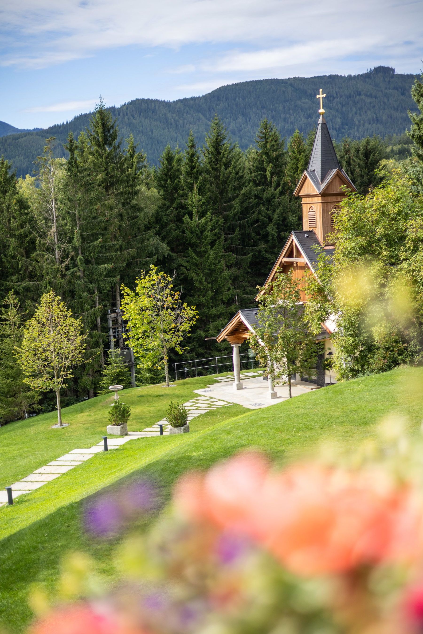 Sommerlicher Blick von der Terrasse auf die Kapelle beim Hotel Knappenhof.