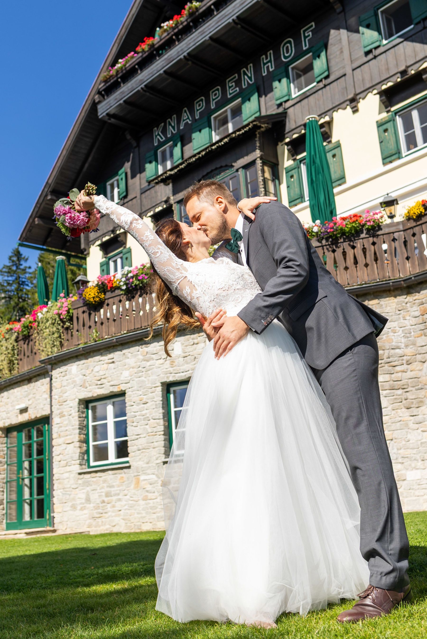 Brautpaar küsst sich vor der Alpenkulisse bei der Hochzeit im Hotel Knappenhof.