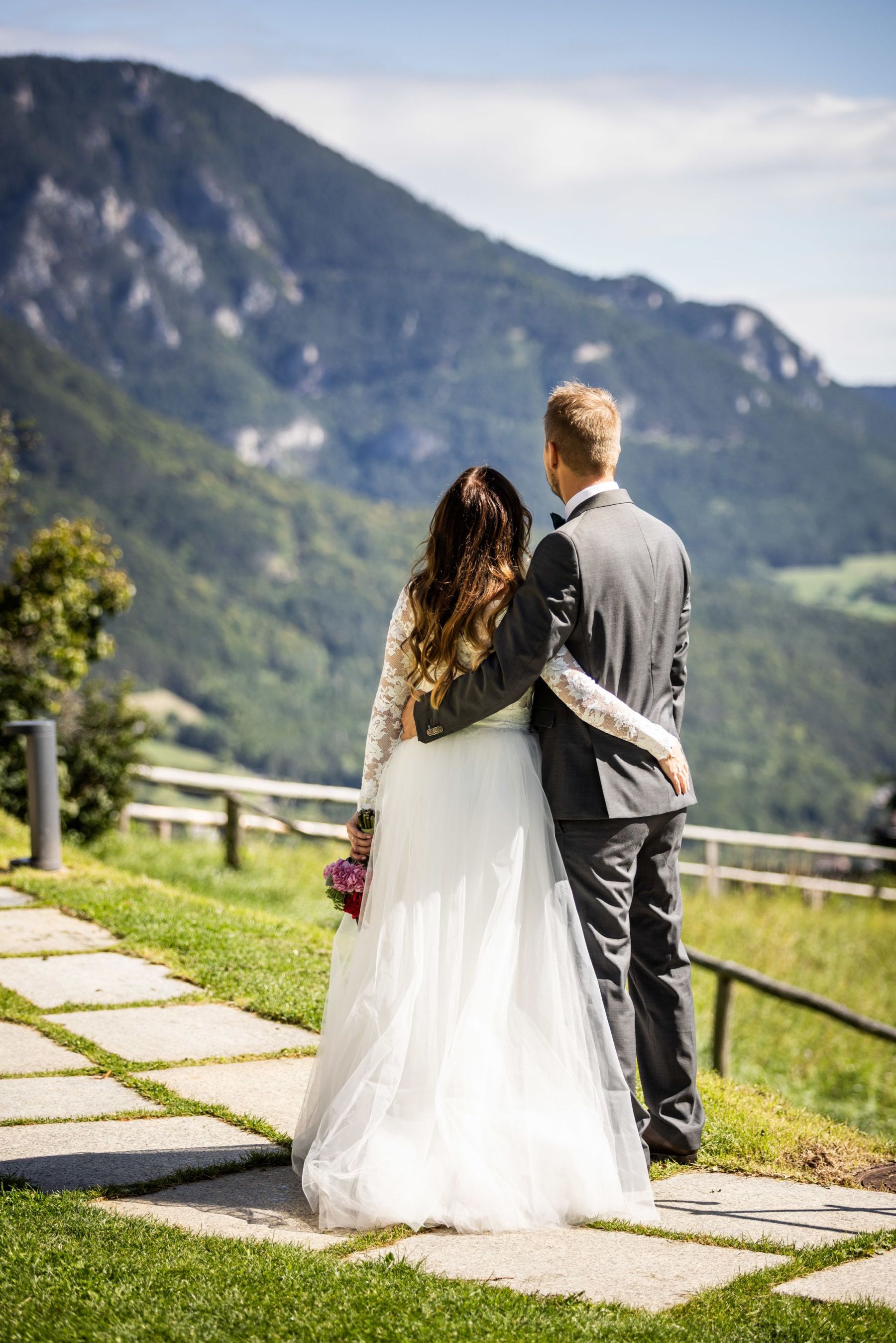 Brautpaar blickt ins Tal am Fuße der Rax bei ihrer Hochzeit im Hotel Knappenhof.