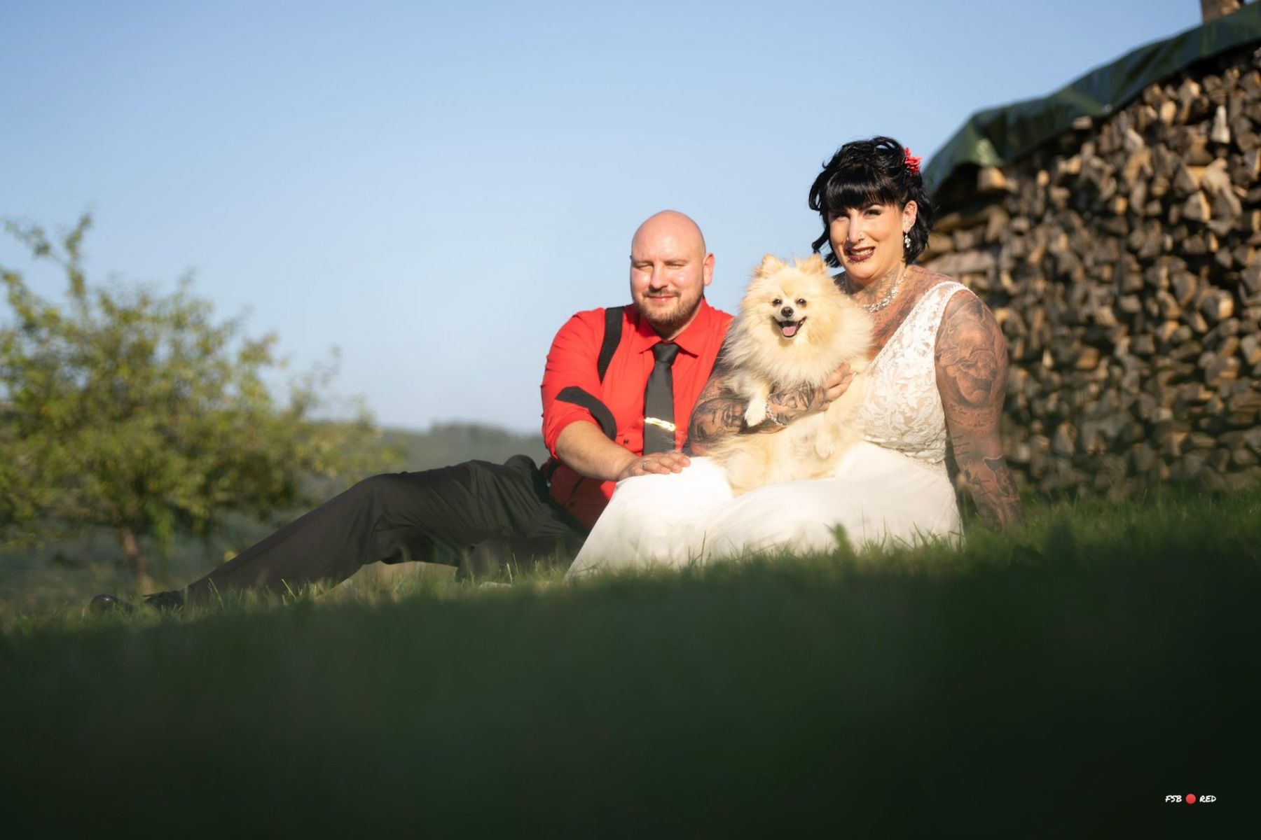 Das Brautpaar entspannt beim Shooting auf der Hochzeitswiese neben dem Festzelt.